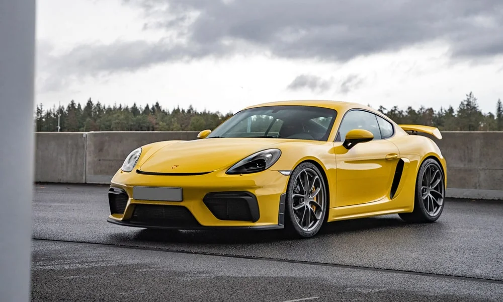 Фото Porsche 718 Cayman GT4 — вид спереди, фото 5. Кузов в жёлтом цвете: рисунок оптики и решётки задаёт узнаваемое «лицо» модели Porsche 718 Cayman GT4 — вид спереди, фото 5