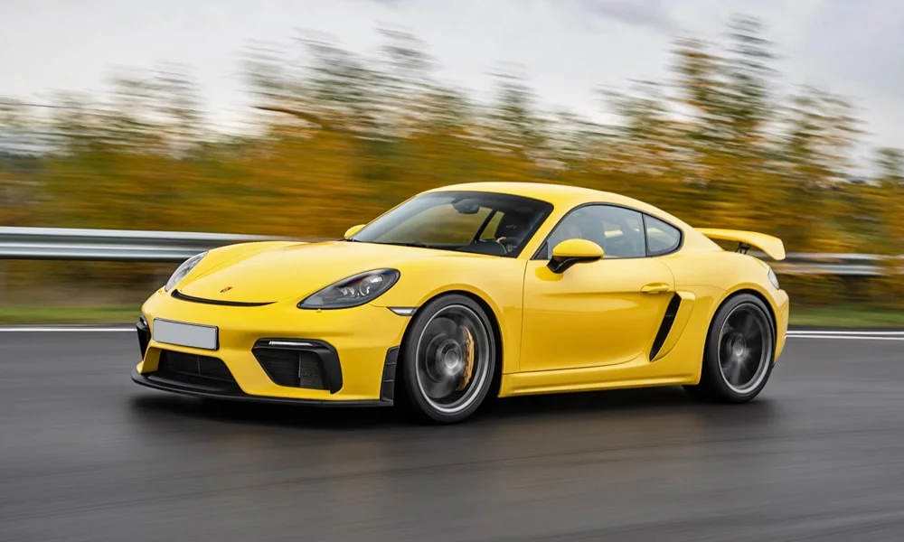 Фото Porsche 718 Cayman GT4 — вид спереди, фото 7. Передок в жёлтом исполнении — крупная светотехника и выразительный бампер. Дневные ходовые огни включаются автоматически с запуском Porsche 718 Cayman GT4 — вид спереди, фото 7