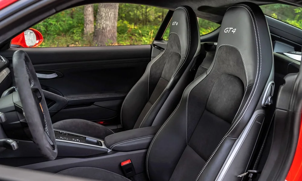 Фото Porsche 718 Cayman GT4 — интерьер. Общий план салона: архитектура панели, консоль и кресла. Светлая гамма зрительно расширяет салон, тёмная — практичнее в уходе Porsche 718 Cayman GT4 — интерьер