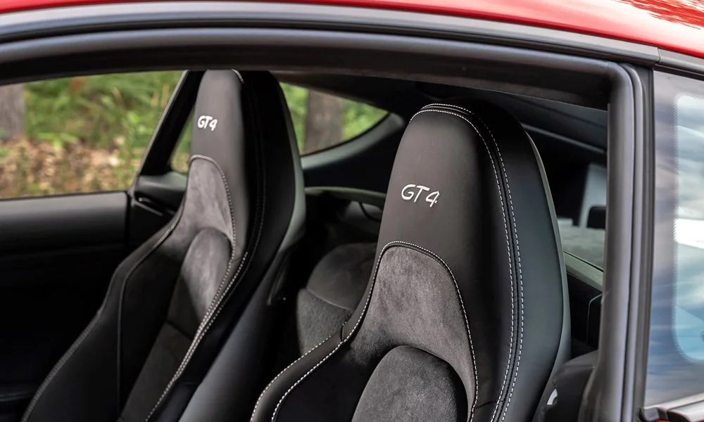 Фото Porsche 718 Cayman GT4 — интерьер, фото 2. Общий план салона: архитектура панели, консоль и кресла. Уровень отделки читается по стыкам панелей и мягким поверхностям в зонах касания Porsche 718 Cayman GT4 — интерьер, фото 2