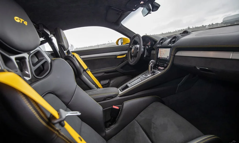 Фото Porsche 718 Cayman GT4 — интерьер, фото 7. Салон в тёмной отделке: архитектура передней панели, консоль и кресла Porsche 718 Cayman GT4 — интерьер, фото 7