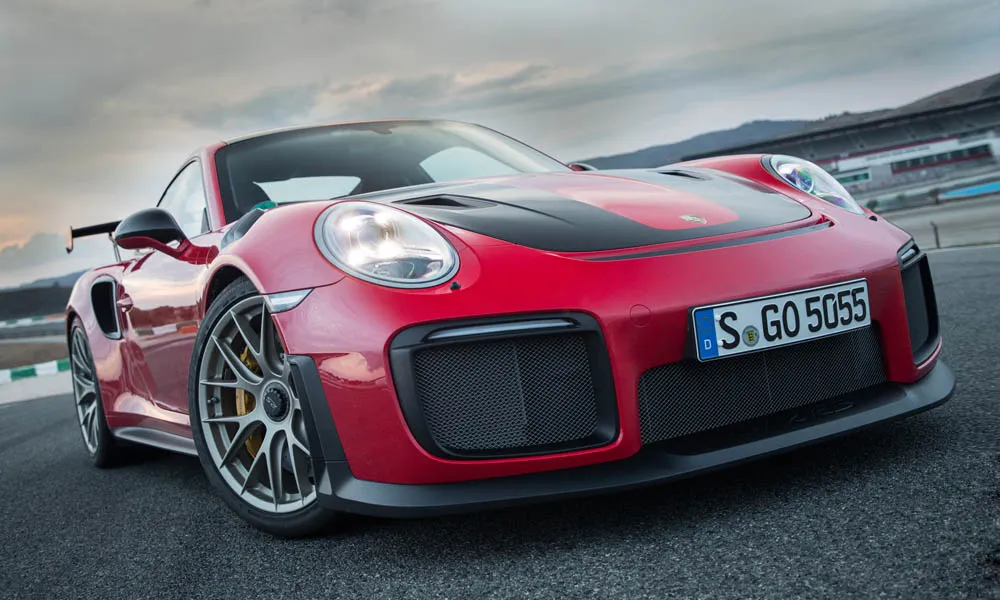 Фото Porsche 911 GT2 RS — вид спереди, фото 10. Передок в красном исполнении — крупная светотехника и выразительный бампер. Рисунок ходовых огней — подпись модели, по нему её узнают в потоке Porsche 911 GT2 RS — вид спереди, фото 10