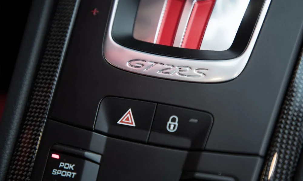 Фото Porsche 911 GT2 RS — селектор коробки передач. Селектор трансмиссии на центральной консоли. Режимы движения и электронный ручник собраны рядом с селектором Porsche 911 GT2 RS — селектор коробки передач