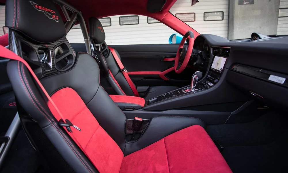 Фото Porsche 911 GT2 RS — интерьер. Общий план салона: архитектура панели, консоль и кресла. Светлая гамма зрительно расширяет салон, тёмная — практичнее в уходе Porsche 911 GT2 RS — интерьер