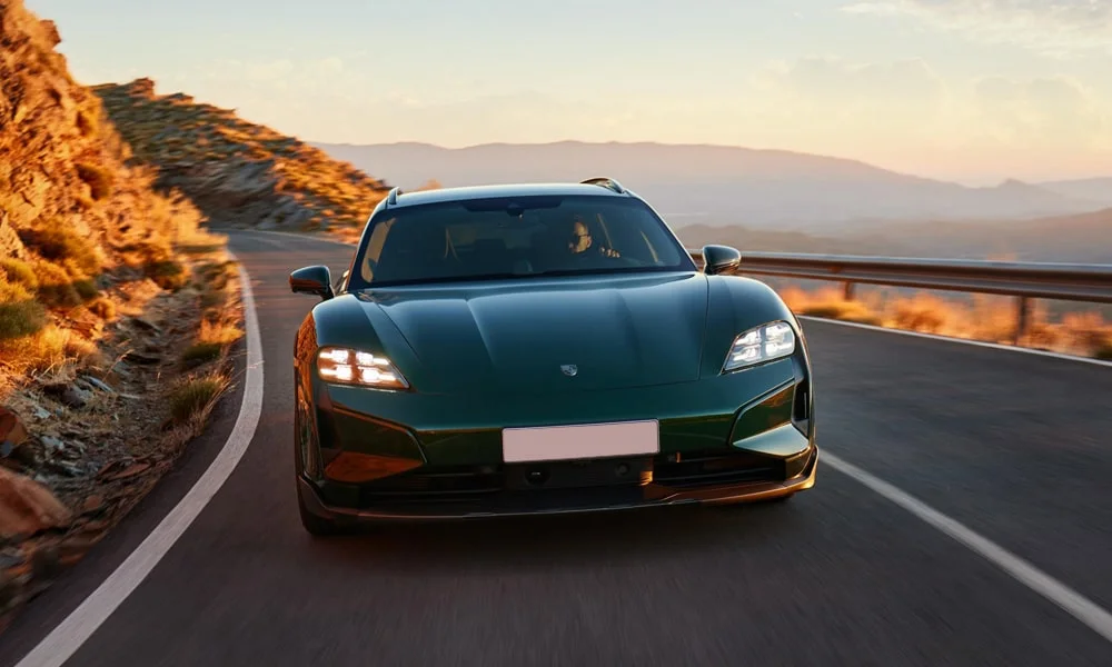 Фото Porsche Taycan Cross Turismo (2024) — вид спереди, фото 6. Кузов в зелёном цвете: рисунок оптики и решётки задаёт узнаваемое «лицо» модели. Дневные ходовые огни включаются автоматически с запуском Porsche Taycan Cross Turismo (2024) — вид спереди, фото 6