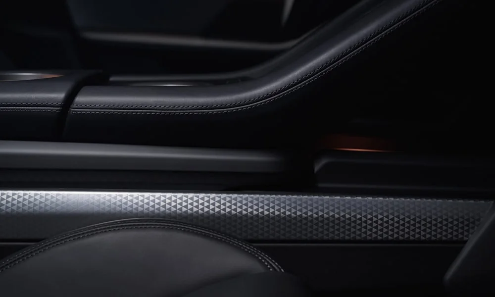 Фото Porsche Taycan Sport Turismo (2024) — дверная карта. Дверная карта в тёмной отделке: подлокотник, динамик и блок стеклоподъёмников Porsche Taycan Sport Turismo (2024) — дверная карта