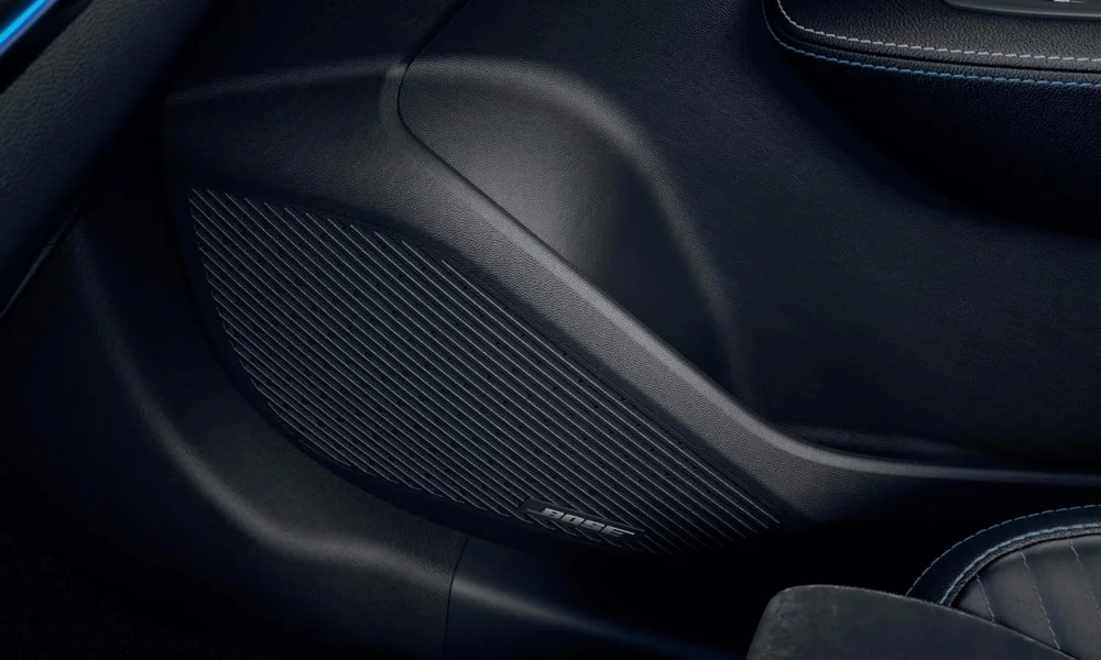 Фото Renault Arkana (2024) — дверная карта. Внутренняя панель двери: сочетание материалов и компоновка управления в тёмно-синей гамме. Решётка динамика в двери — часть штатной акустики Renault Arkana (2024) — дверная карта