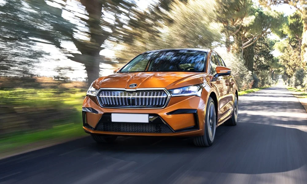 Фото Skoda Enyaq Coupe (2024) — вид спереди, фото 5. Оранжевый кузов, строгая симметрия оптики — базовый ракурс знакомства с дизайном Skoda Enyaq Coupe (2024) — вид спереди, фото 5