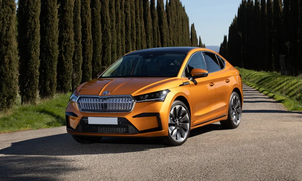 Фото Skoda Enyaq Coupe (2024) — вид спереди, фото 6. Передок в оранжевом исполнении — крупная светотехника и выразительный бампер. Дневные ходовые огни включаются автоматически с запуском Skoda Enyaq Coupe (2024) — вид спереди, фото 6