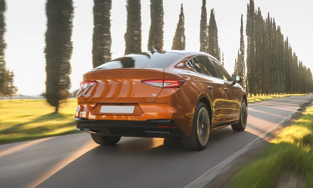 Фото Skoda Enyaq Coupe (2024) — вид сзади, фото 5. Корма в оранжевом цвете: графика фонарей и пластика пятой двери. Светодиодная полоса или раздельные секции — задняя оптика стала главным украшением кормы Skoda Enyaq Coupe (2024) — вид сзади, фото 5