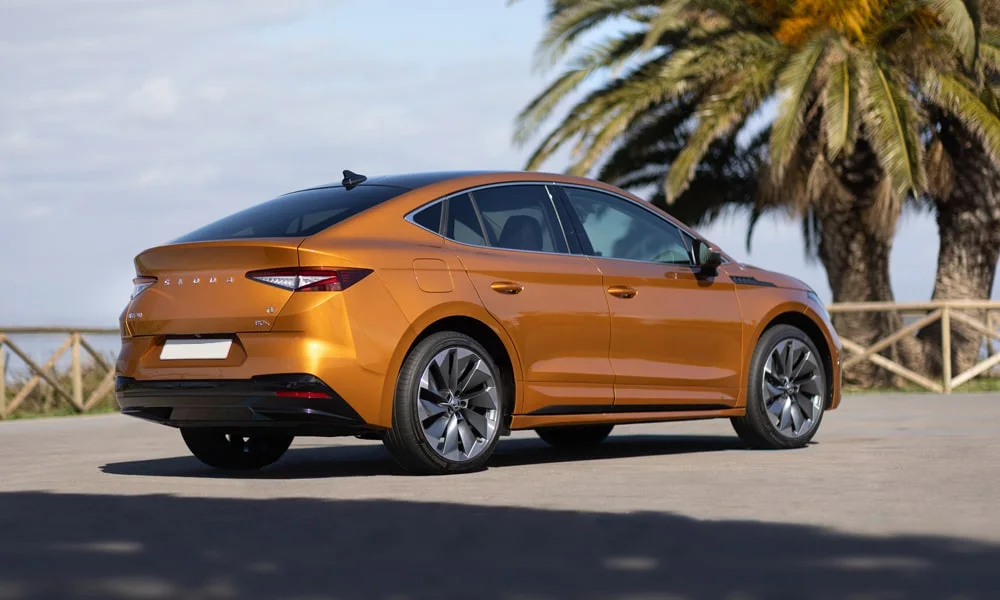 Фото Skoda Enyaq Coupe (2024) — вид сзади, фото 6. Линия крыши, стойки и задняя дверь в оранжевом исполнении. Светодиодная полоса или раздельные секции — задняя оптика стала главным украшением кормы Skoda Enyaq Coupe (2024) — вид сзади, фото 6
