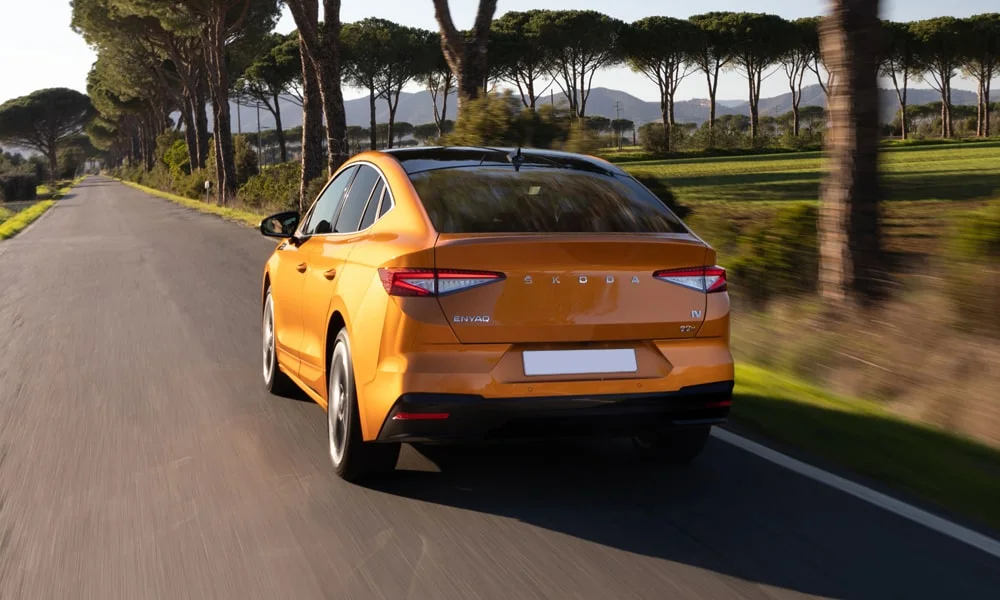 Фото Skoda Enyaq Coupe (2024) — вид сзади, фото 7. Линия крыши, стойки и задняя дверь в оранжевом исполнении Skoda Enyaq Coupe (2024) — вид сзади, фото 7