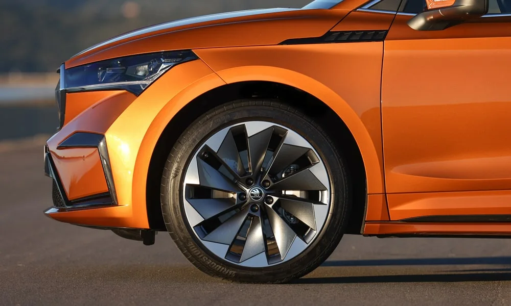Фото Skoda Enyaq Coupe (2024) — вид сбоку, фото 4. Оранжевый кузов в профиль — пропорции, высота посадки и дизайн дисков Skoda Enyaq Coupe (2024) — вид сбоку, фото 4