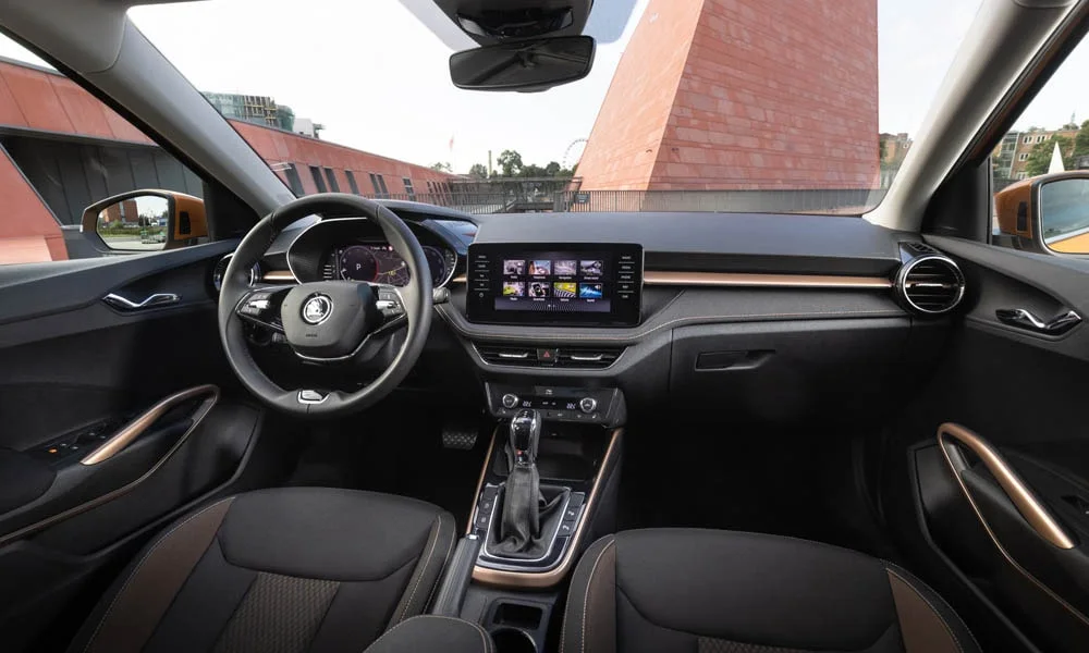 Фото Skoda Fabia — передняя панель. Архитектура передней панели: ярусы, вставки и консоль в коричневой гамме. Мягкие материалы верхнего яруса и вставки задают уровень интерьера Skoda Fabia — передняя панель