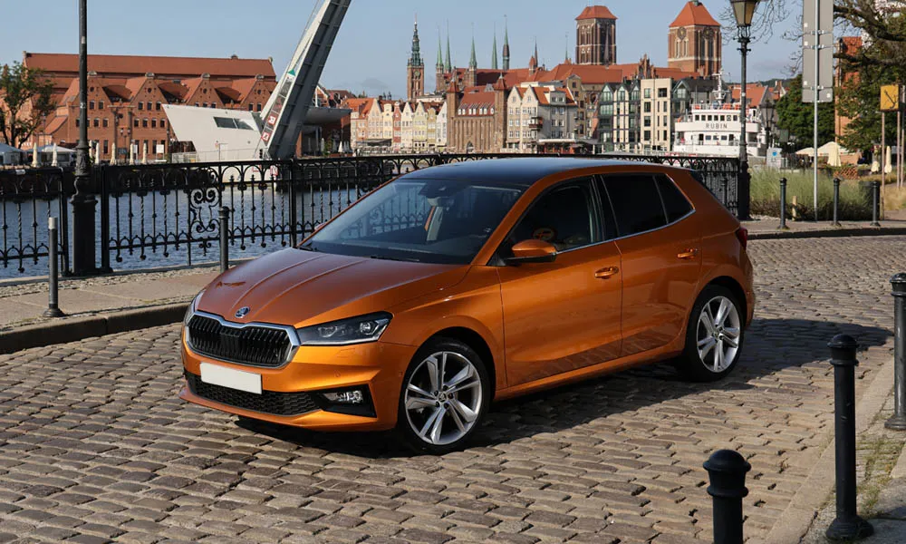 Фото Skoda Fabia — вид спереди, фото 2. Оранжевый кузов, строгая симметрия оптики — базовый ракурс знакомства с дизайном. Дневные ходовые огни включаются автоматически с запуском Skoda Fabia — вид спереди, фото 2