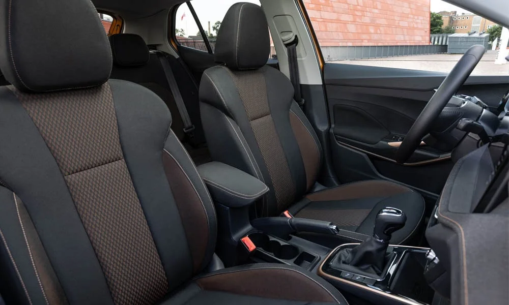 Фото Skoda Fabia — интерьер. Салон в коричневой отделке: архитектура передней панели, консоль и кресла. Уровень отделки читается по стыкам панелей и мягким поверхностям в зонах касания Skoda Fabia — интерьер
