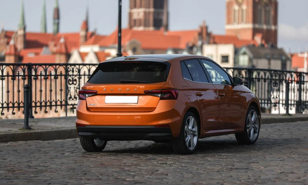 Фото Skoda Fabia — вид сзади, фото 6. Корма в оранжевом цвете: графика фонарей и пластика пятой двери. Насадки выхлопа или их имитация внизу бампера различают версии Skoda Fabia — вид сзади, фото 6
