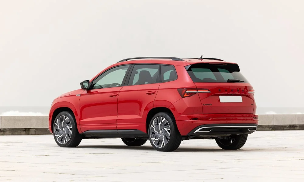 Фото Skoda Karoq (2024) — вид сзади, фото 8. Красный кузов сзади — фонари и бампер определяют ночной образ модели. Насадки выхлопа или их имитация внизу бампера различают версии Skoda Karoq (2024) — вид сзади, фото 8