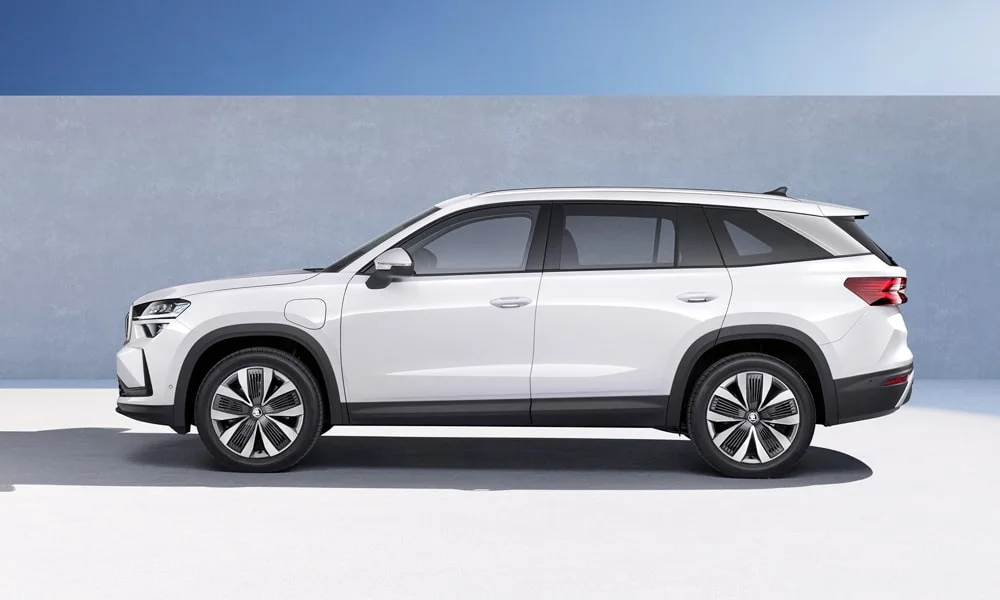 Фото Skoda Kodiaq (2024) — вид сбоку, фото 3. Сбоку читаются линия остекления и характер выштамповок на белом кузове Skoda Kodiaq (2024) — вид сбоку, фото 3