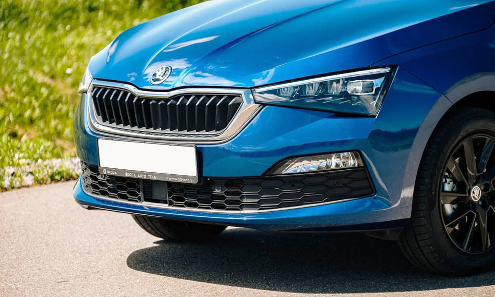 Фото Skoda Rapid — вид спереди, фото 10. Синий кузов, строгая симметрия оптики — базовый ракурс знакомства с дизайном. Рисунок ходовых огней — подпись модели, по нему её узнают в потоке Skoda Rapid — вид спереди, фото 10