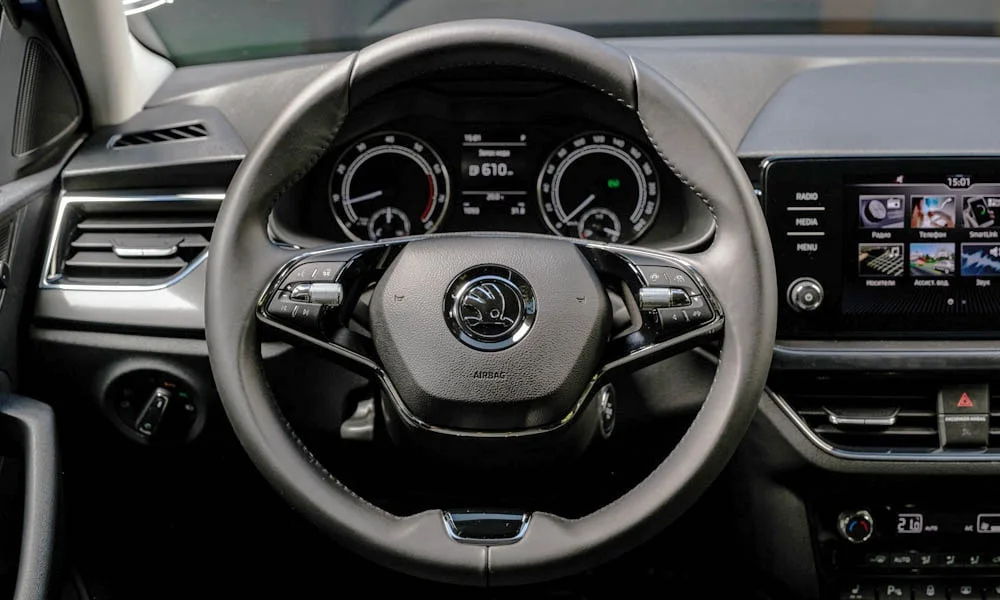 Фото Skoda Rapid — руль. Обшивка обода и компоновка спиц крупным планом. Обогрев обода — опция, которую оценят зимой Skoda Rapid — руль
