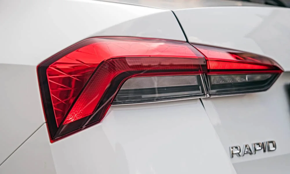 Фото Skoda Rapid — задние фонари. Рассеиватель фонаря вблизи: компоновка секций габарита, стопа и поворотника. Динамические поворотники с бегущей индикацией встречаются в старших комплектациях Skoda Rapid — задние фонари
