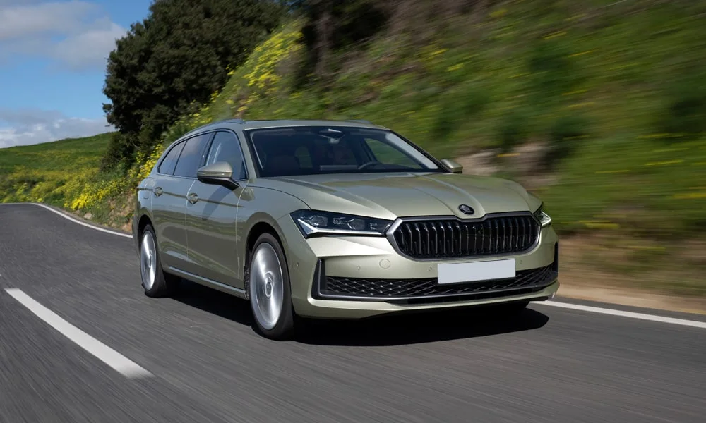 Фото Skoda Superb Combi (2024) — вид спереди, фото 3. Оптика, решётка и бампер — первое впечатление о модели. Рисунок ходовых огней — подпись модели, по нему её узнают в потоке Skoda Superb Combi (2024) — вид спереди, фото 3