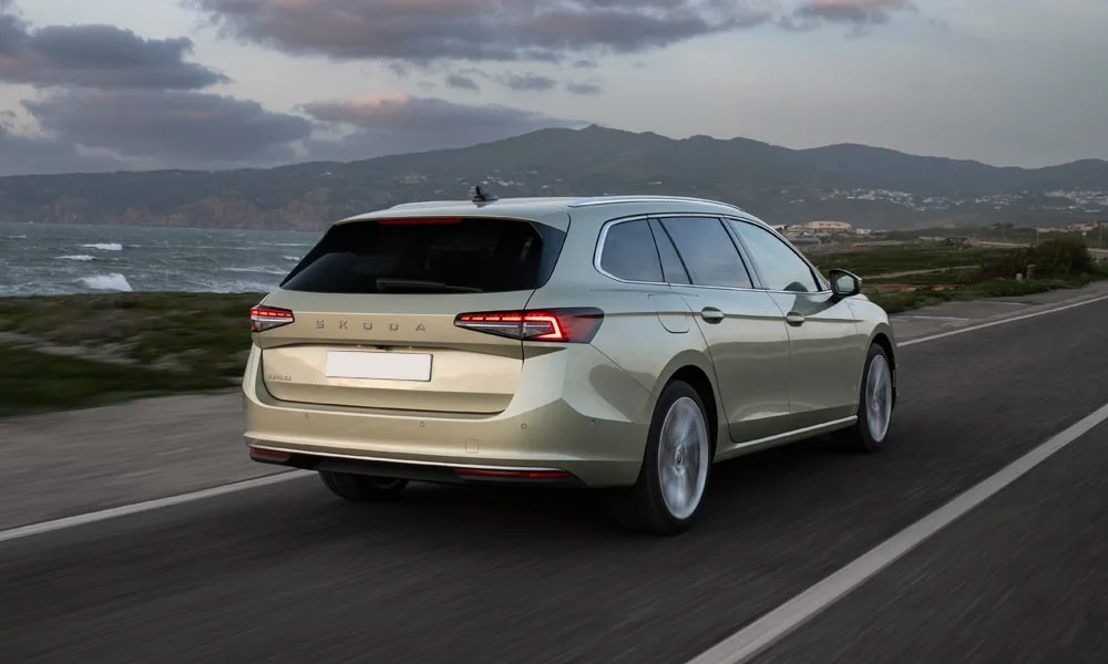Фото Skoda Superb Combi (2024) — вид сзади, фото 4. Бежевый кузов сзади — фонари и бампер определяют ночной образ модели. Насадки выхлопа или их имитация внизу бампера различают версии Skoda Superb Combi (2024) — вид сзади, фото 4