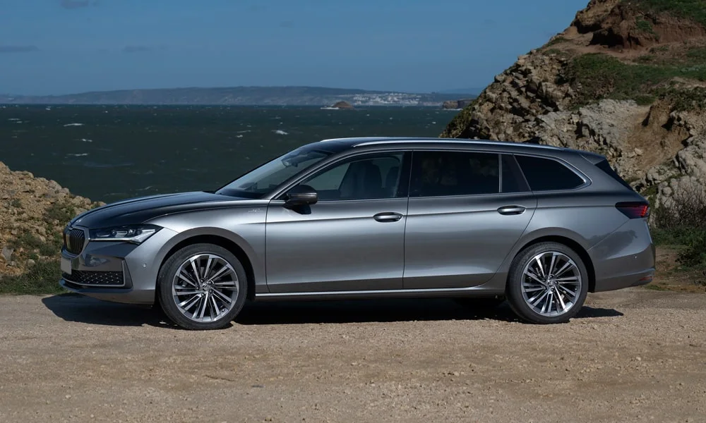Фото Skoda Superb Combi (2024) — вид сбоку, фото 5. Сбоку читаются линия остекления и характер выштамповок на серебристом кузове Skoda Superb Combi (2024) — вид сбоку, фото 5