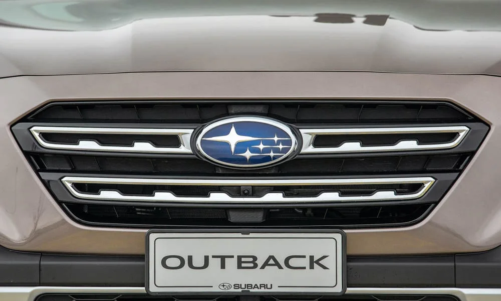 Фото Subaru Outback — решётка радиатора. Фирменный рисунок облицовки — визитная карточка марки. Активные жалюзи за решёткой закрываются на трассе ради аэродинамики — есть у ряда моделей Subaru Outback — решётка радиатора