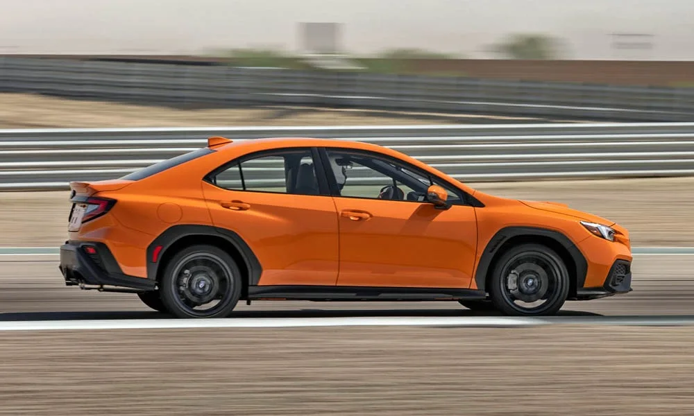 Фото Subaru WRX STI (2024) — вид сбоку, фото 2. Профиль кузова: колёсная база, свесы и линия остекления. Хромированные или чёрные молдинги окон отличают комплектации Subaru WRX STI (2024) — вид сбоку, фото 2