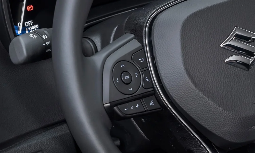Фото Suzuki Swace — руль. Обшивка обода и компоновка спиц крупным планом. Правильная посадка: руки на «9 и 3», приборы читаются поверх обода Suzuki Swace — руль