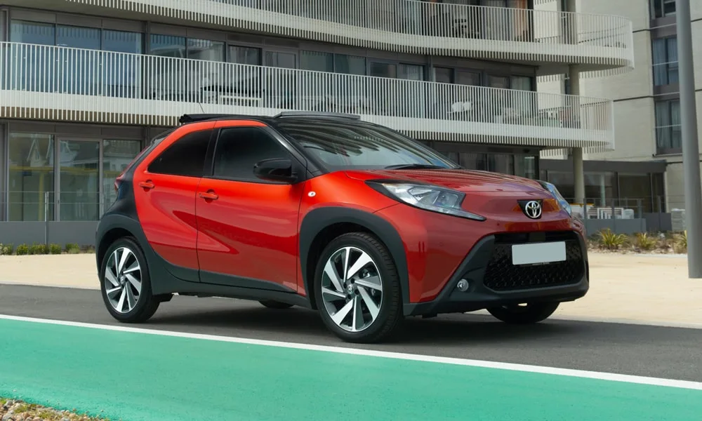 Фото Toyota Aygo X — вид спереди, фото 5. Передок в красном исполнении — крупная светотехника и выразительный бампер. Дневные ходовые огни включаются автоматически с запуском Toyota Aygo X — вид спереди, фото 5