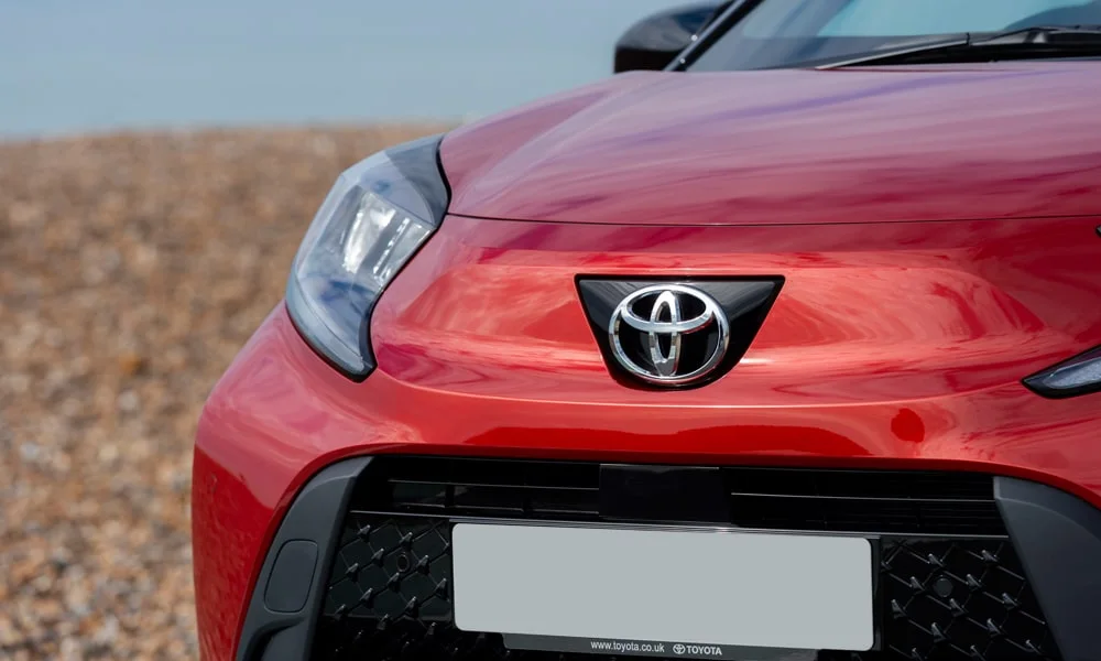 Фото Toyota Aygo X — вид спереди, фото 9. Анфас: пропорции капота, посадка кузова и графика ходовых огней. Рисунок ходовых огней — подпись модели, по нему её узнают в потоке Toyota Aygo X — вид спереди, фото 9