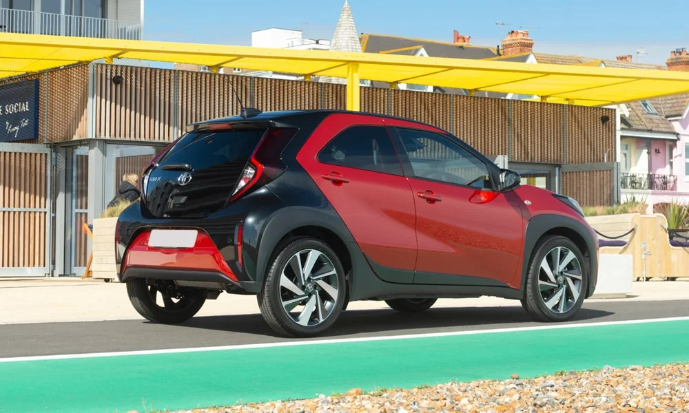 Фото Toyota Aygo X — вид сзади, фото 4. Красный кузов сзади — фонари и бампер определяют ночной образ модели Toyota Aygo X — вид сзади, фото 4