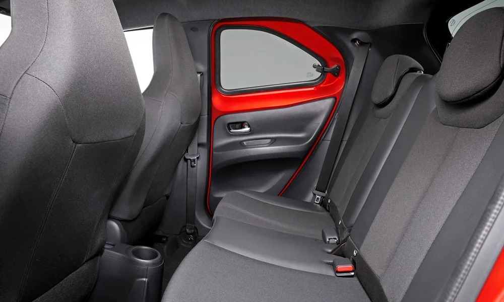 Фото Toyota Aygo X — задние сиденья. Посадка второго ряда: подголовники и подлокотник Toyota Aygo X — задние сиденья