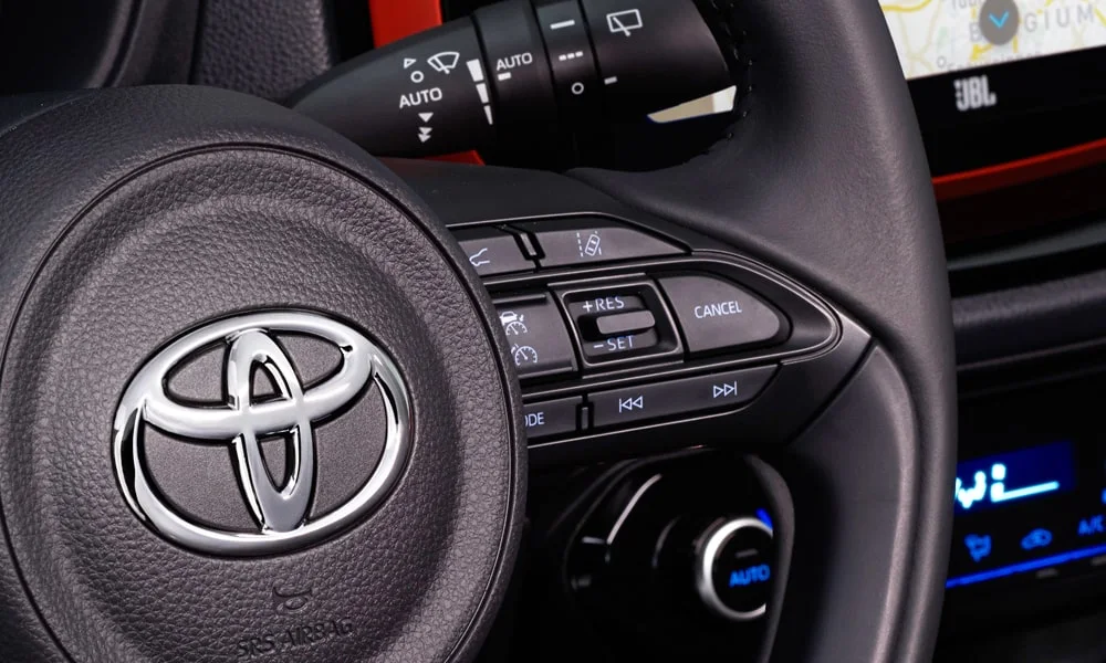 Фото Toyota Aygo X — руль, фото 2. Обшивка обода и компоновка спиц крупным планом. Правильная посадка: руки на «9 и 3», приборы читаются поверх обода Toyota Aygo X — руль, фото 2