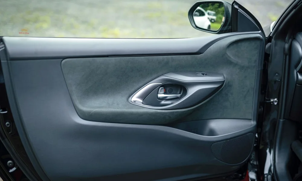 Фото Toyota GR Yaris — дверная карта. Дверная карта в тёмной отделке: подлокотник, динамик и блок стеклоподъёмников. Мягкая вставка в зоне локтя — то, что чувствуешь каждый день Toyota GR Yaris — дверная карта