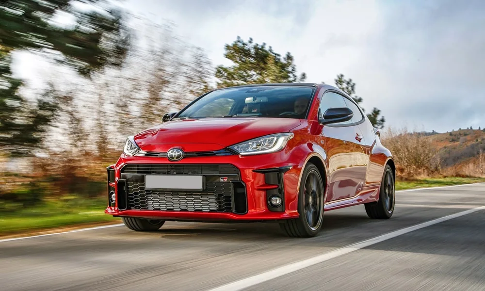 Фото Toyota GR Yaris — вид спереди, фото 3. Кузов в красном цвете: рисунок оптики и решётки задаёт узнаваемое «лицо» модели Toyota GR Yaris — вид спереди, фото 3