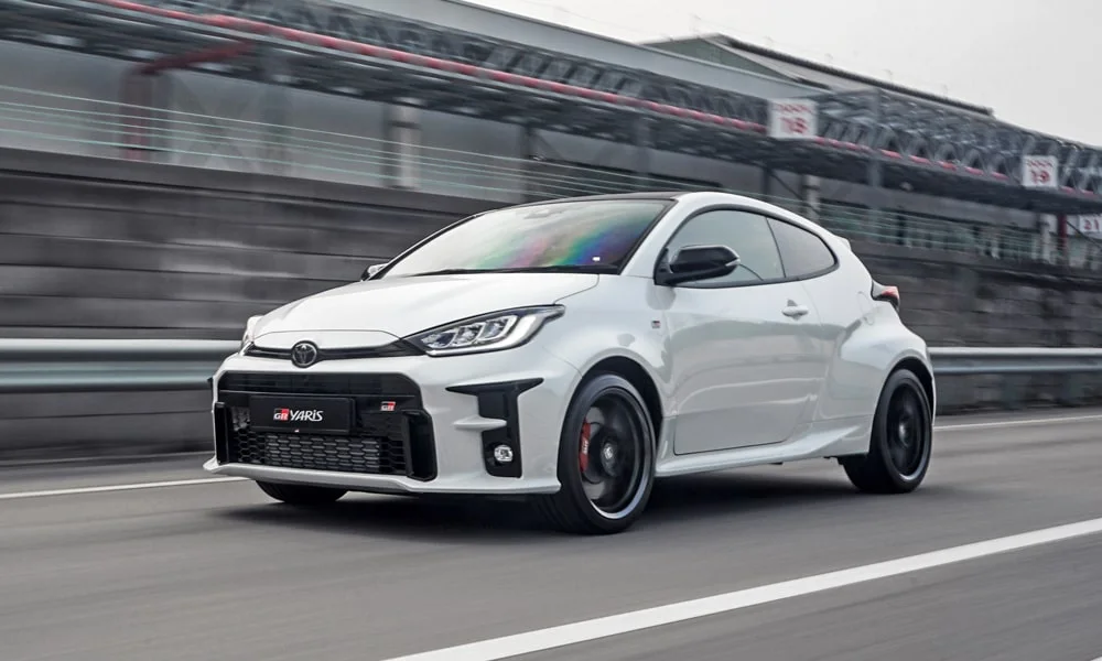 Фото Toyota GR Yaris — вид спереди, фото 8. Белый кузов, строгая симметрия оптики — базовый ракурс знакомства с дизайном Toyota GR Yaris — вид спереди, фото 8