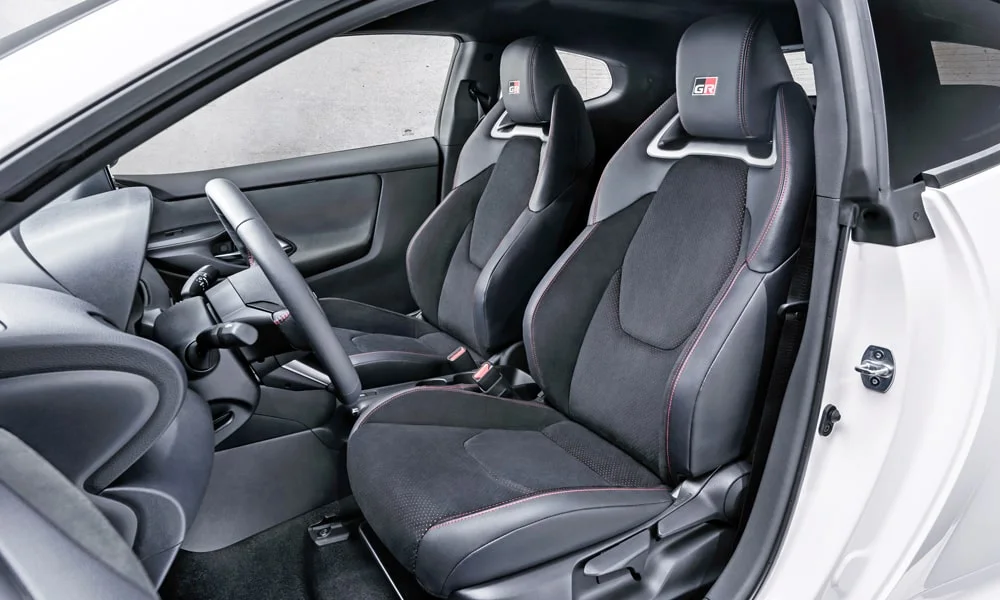 Фото Toyota GR Yaris — передние сиденья. Водительское и пассажирское кресла: обивка из алькантаре, профиль с боковой поддержкой Toyota GR Yaris — передние сиденья