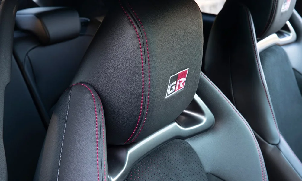 Фото Toyota GR Yaris — интерьер, фото 2. Общий план салона: архитектура панели, консоль и кресла. Светлая гамма зрительно расширяет салон, тёмная — практичнее в уходе Toyota GR Yaris — интерьер, фото 2