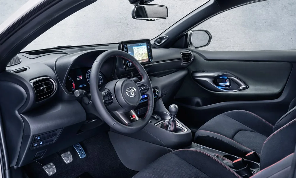 Фото Toyota GR Yaris — интерьер, фото 3. Общий план салона: архитектура панели, консоль и кресла. Уровень отделки читается по стыкам панелей и мягким поверхностям в зонах касания Toyota GR Yaris — интерьер, фото 3