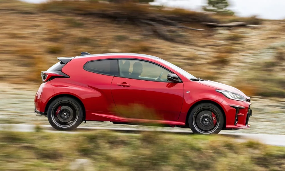 Фото Toyota GR Yaris — вид сбоку, фото 3. Красный кузов в профиль — пропорции, высота посадки и дизайн дисков Toyota GR Yaris — вид сбоку, фото 3