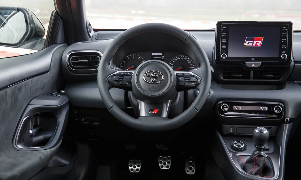 Фото Toyota GR Yaris — руль. Обшивка обода и компоновка спиц крупным планом. Обогрев обода — опция, которую оценят зимой Toyota GR Yaris — руль