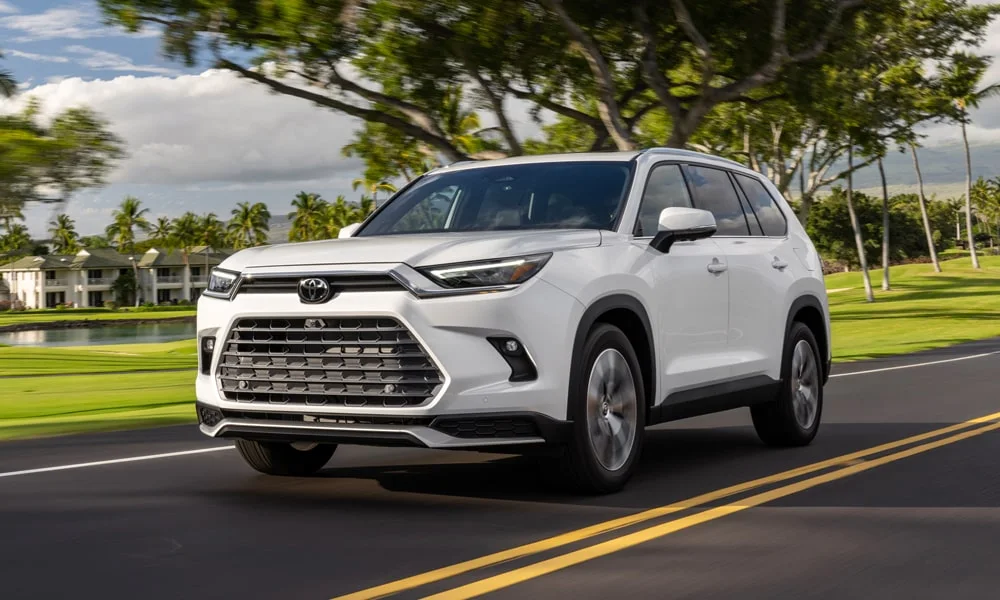 Фото Toyota Grand Highlander (2024) — вид спереди, фото 10. Белый кузов, строгая симметрия оптики — базовый ракурс знакомства с дизайном Toyota Grand Highlander (2024) — вид спереди, фото 10