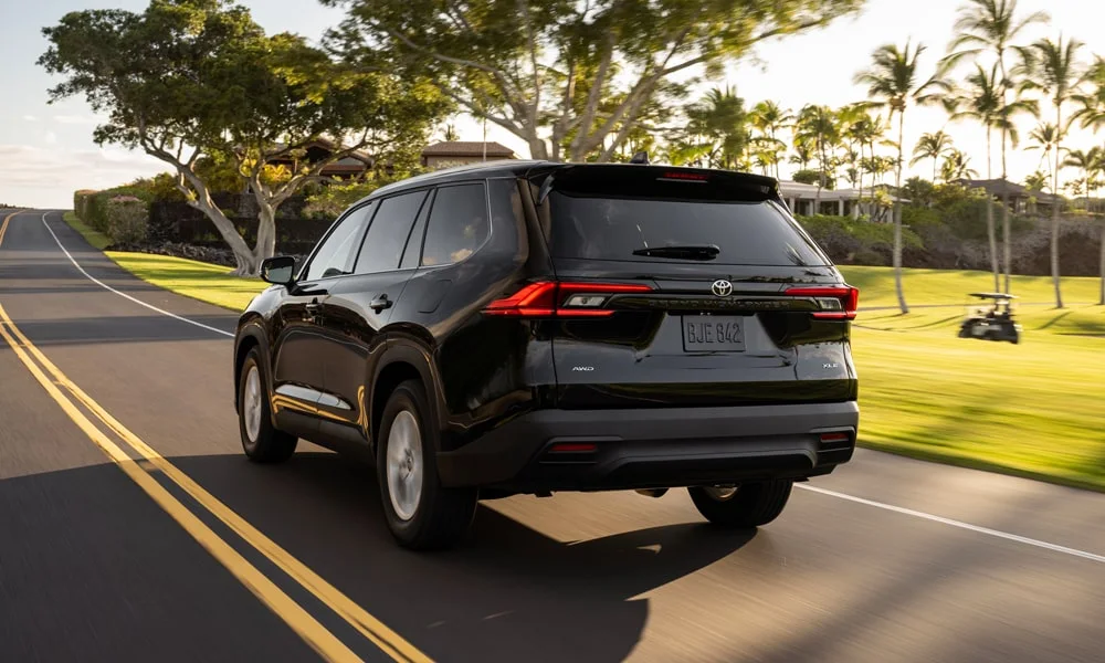 Фото Toyota Grand Highlander (2024) — вид сзади, фото 3. Чёрный кузов сзади — фонари и бампер определяют ночной образ модели. Светодиодная полоса или раздельные секции — задняя оптика стала главным украшением кормы Toyota Grand Highlander (2024) — вид сзади, фото 3