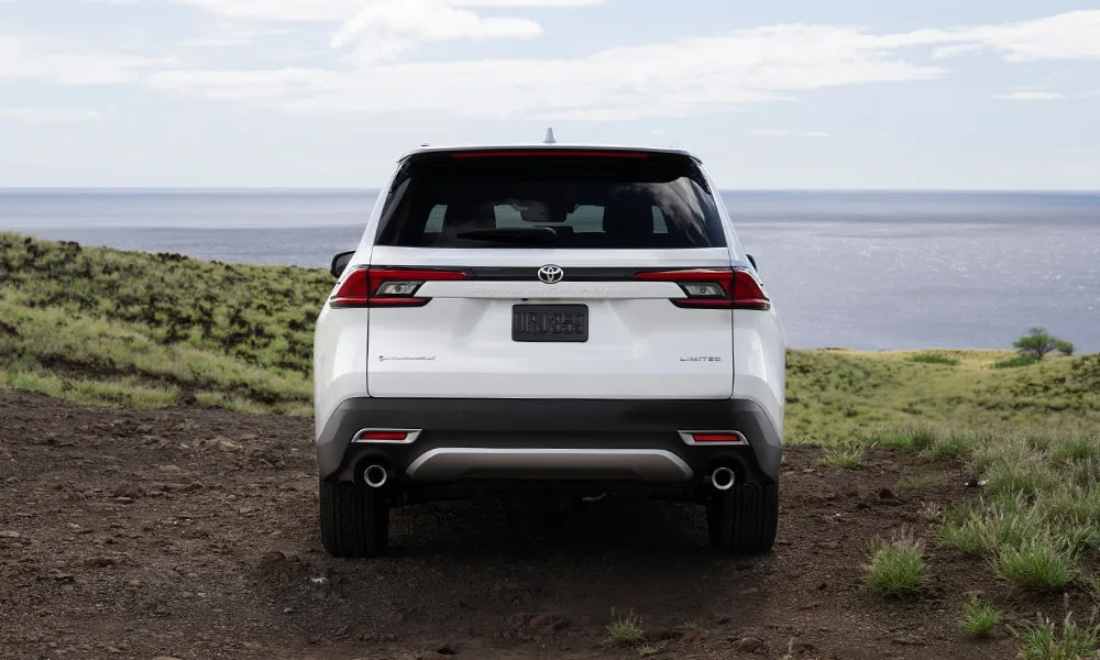 Фото Toyota Grand Highlander (2024) — вид сзади, фото 8. Линия крыши, стойки и задняя дверь в белом исполнении. Насадки выхлопа или их имитация внизу бампера различают версии Toyota Grand Highlander (2024) — вид сзади, фото 8