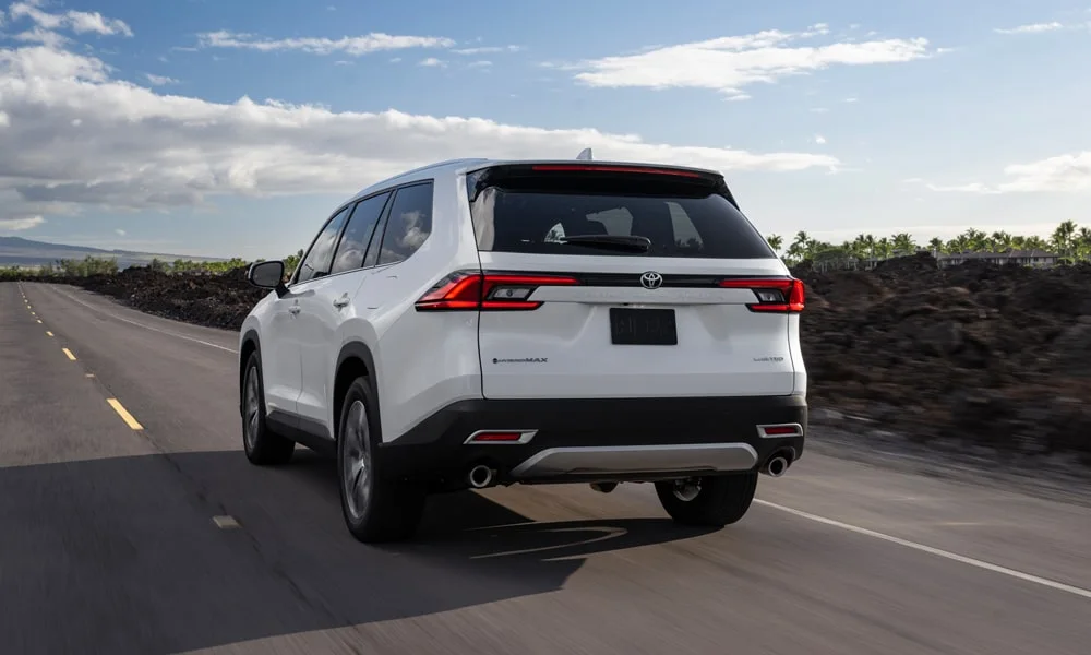 Фото Toyota Grand Highlander (2024) — вид сзади, фото 9. Корма в белом цвете: графика фонарей и пластика пятой двери. Светодиодная полоса или раздельные секции — задняя оптика стала главным украшением кормы Toyota Grand Highlander (2024) — вид сзади, фото 9