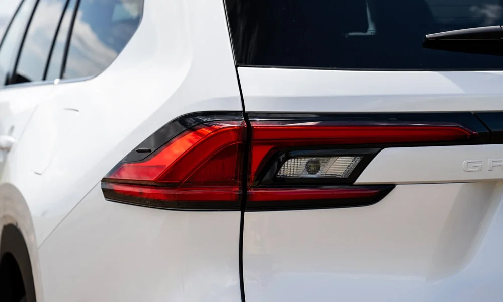 Фото Toyota Grand Highlander (2024) — задние фонари. Рассеиватель фонаря вблизи: компоновка секций габарита, стопа и поворотника. Динамические поворотники с бегущей индикацией встречаются в старших комплектациях Toyota Grand Highlander (2024) — задние фонари